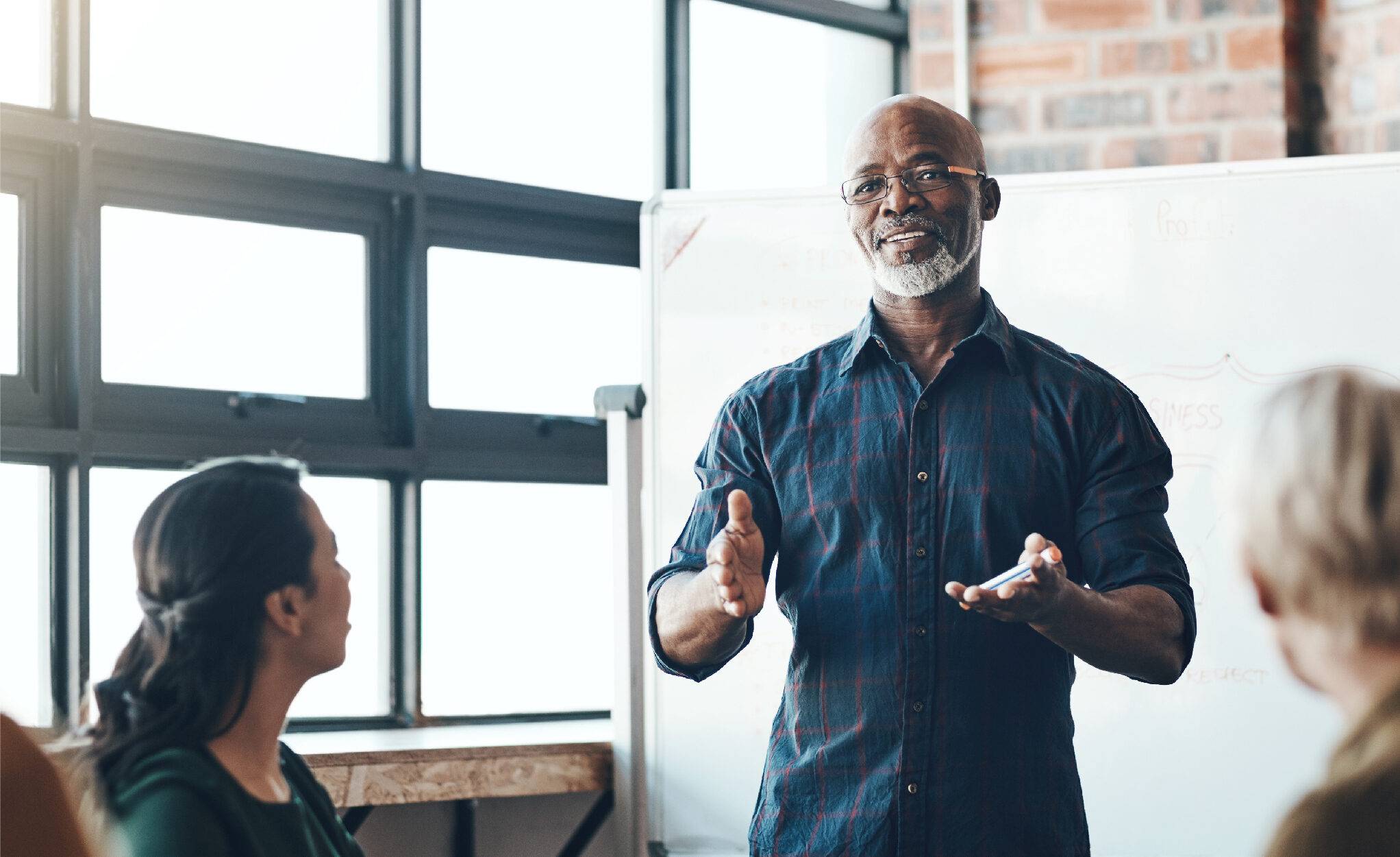 A bearded man is speaking to a small group of people.